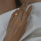 Hand wearing a ciel ring on a white dress