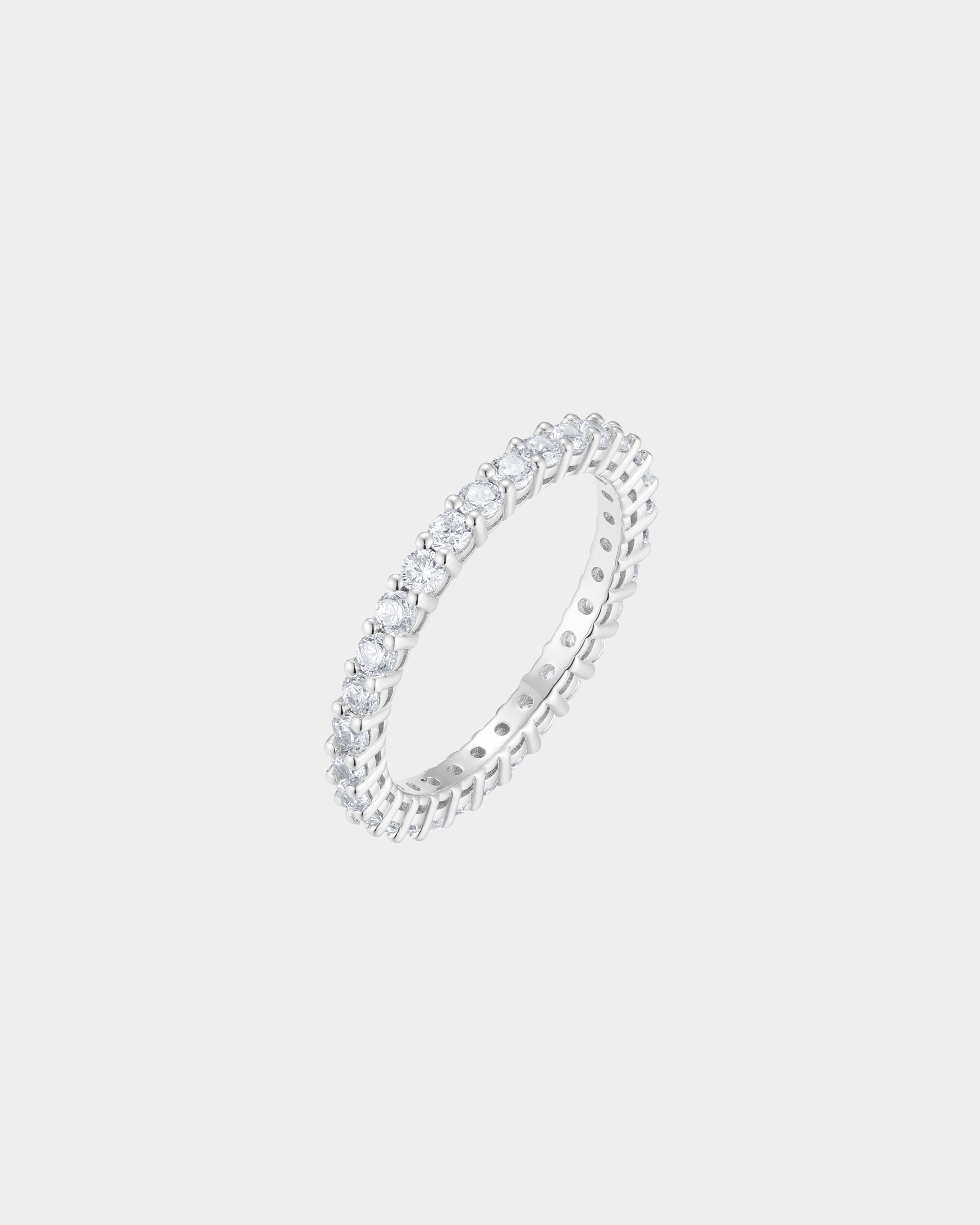 Silver ring with small diamonds on a light gray background