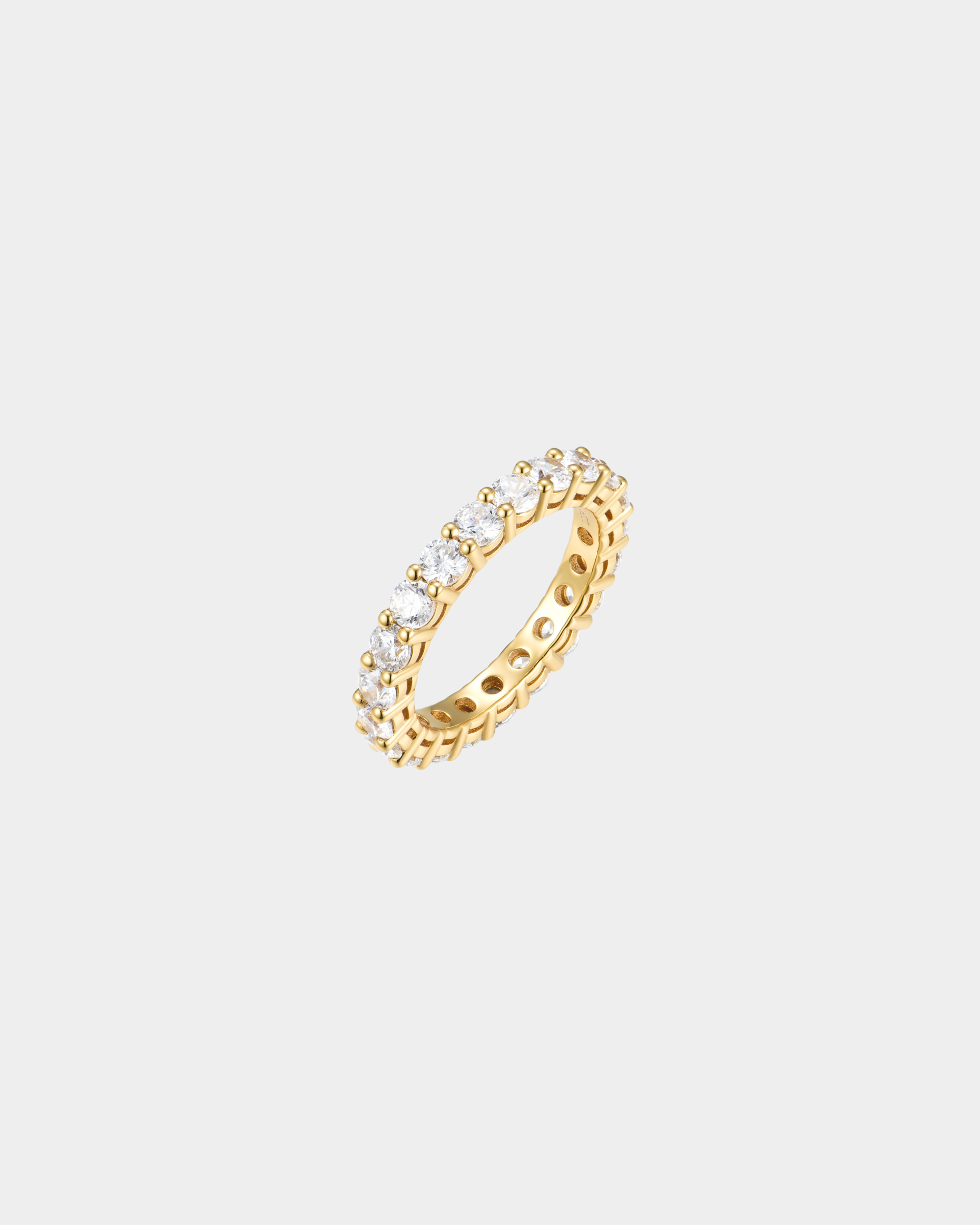 Gold ring with embedded diamonds on a light gray background