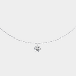 Delicate silver necklace with a small diamond pendant on a light gray background