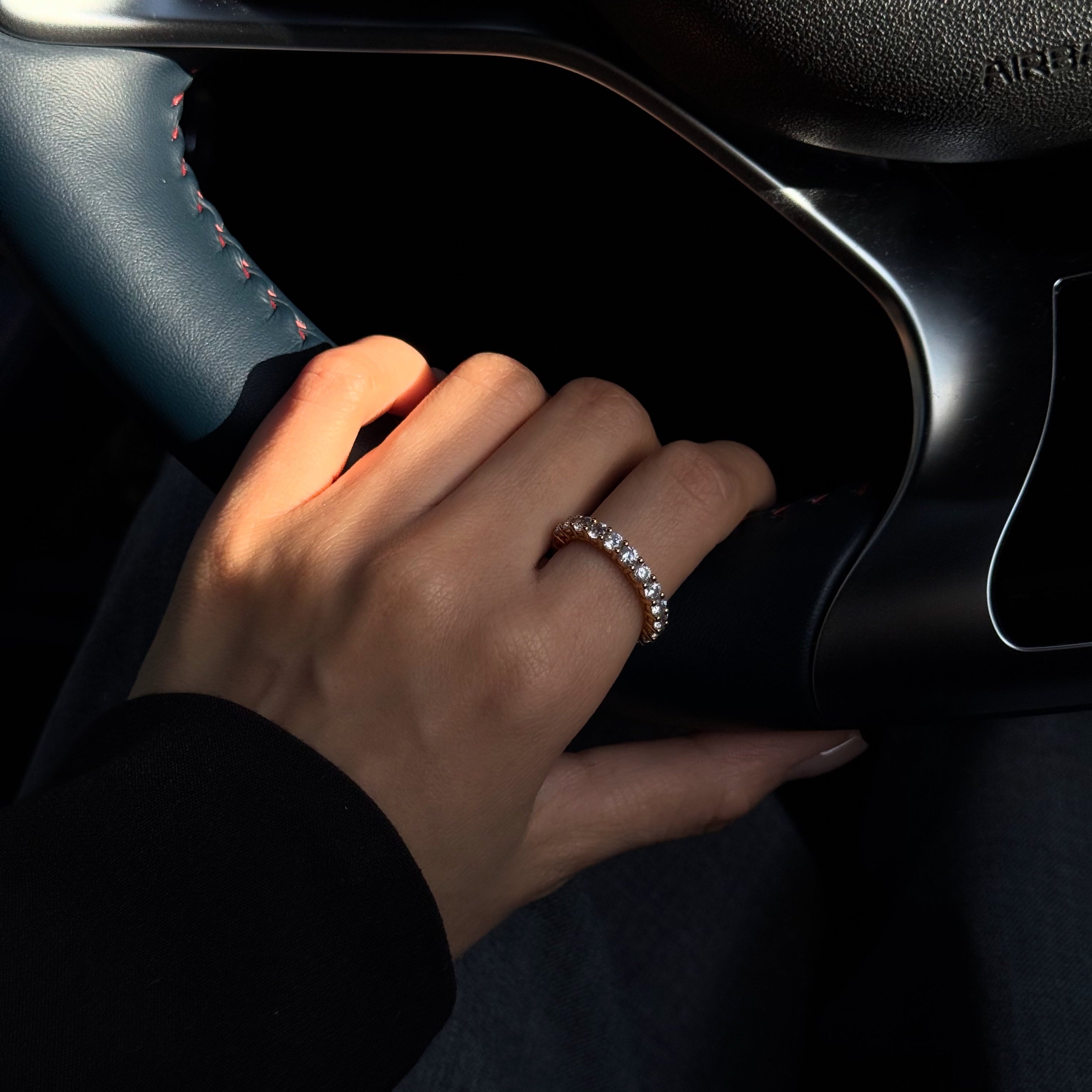 Hand with lume jewellery's amore ring on a car dashboard