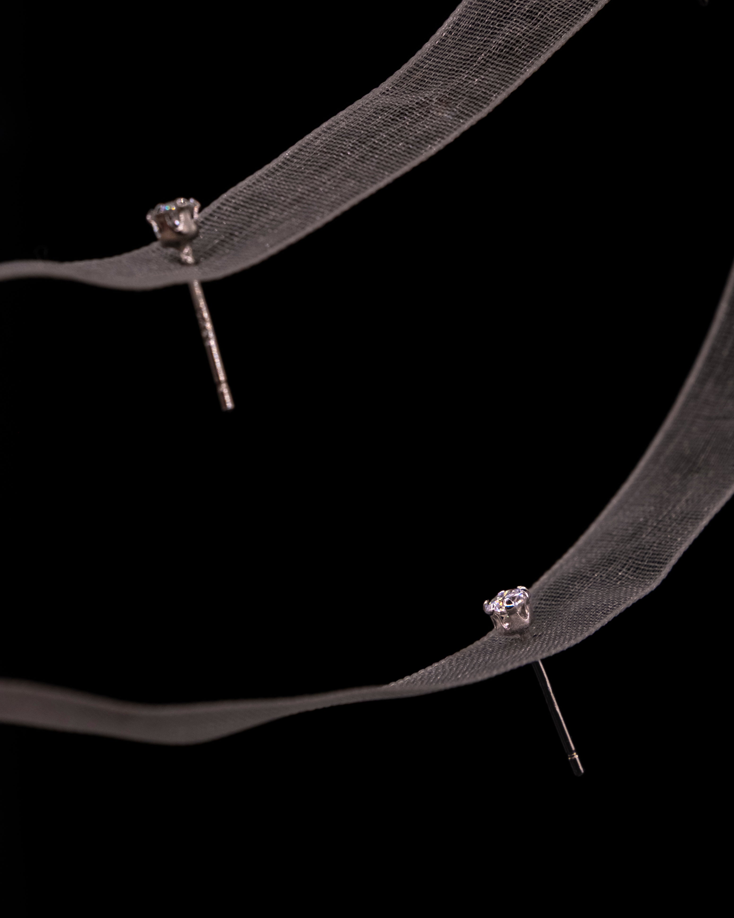 Pair of LUME's Stella stud earrings on a black background