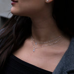 Close-up of a woman wearing a delicate necklace with a blurred background