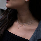 Close-up of a woman wearing a delicate necklace with a blurred background