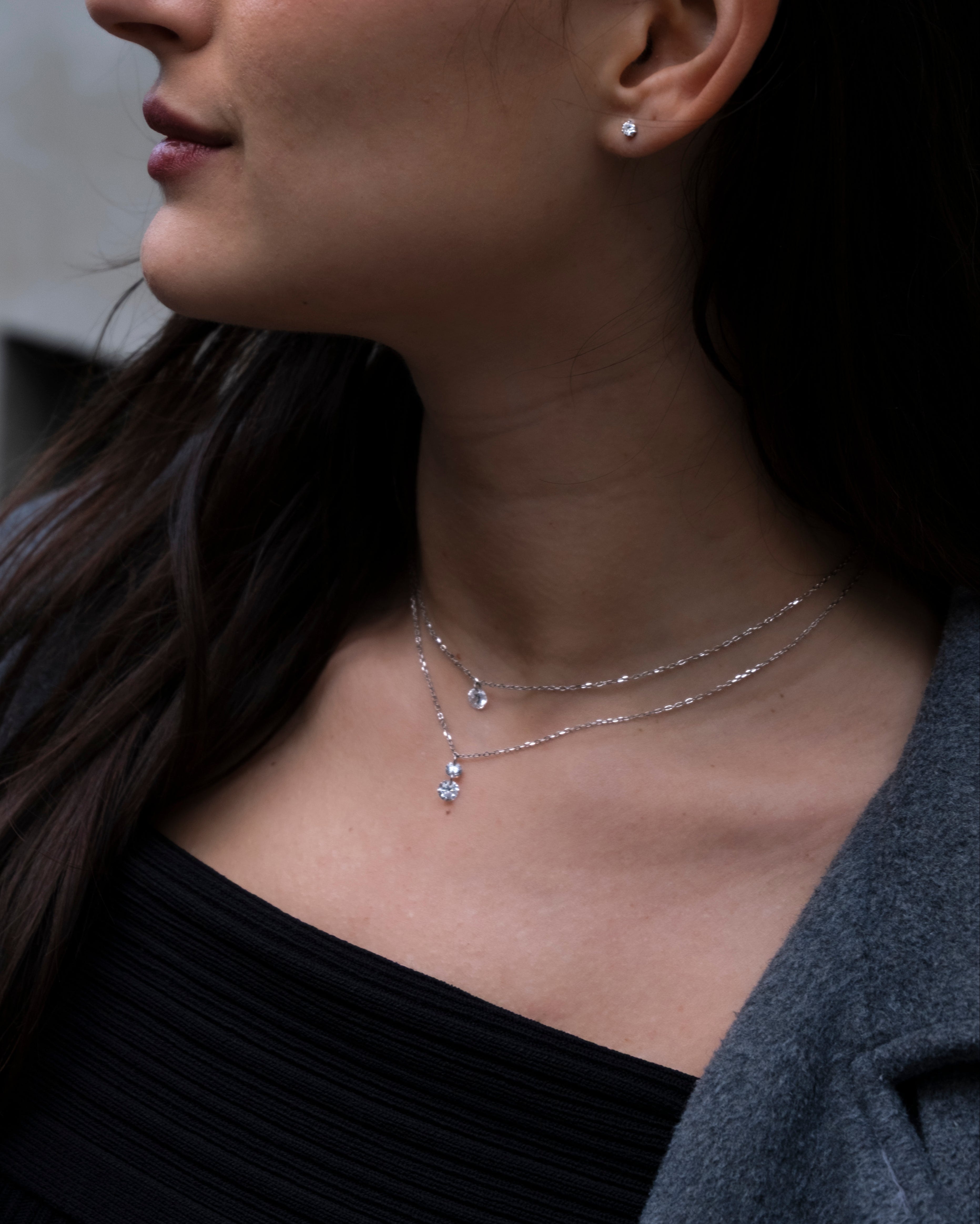 Close-up of a woman wearing a delicate necklace with a blurred background