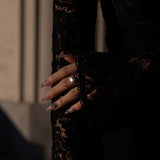 Close-up of a hand wearing lume jewellery's melora ring with a blurred background