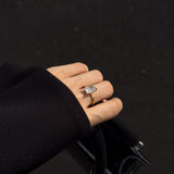 elodie ring on a hand holding a black back 