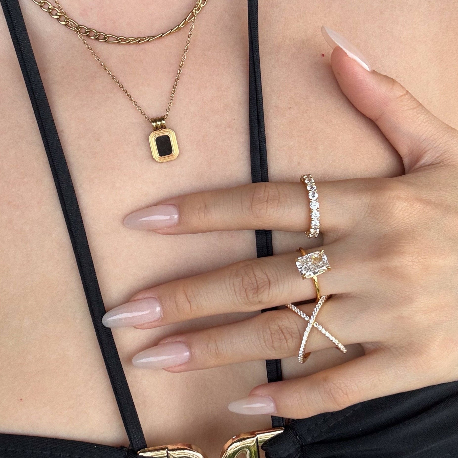 Close-up of a hand wearing lume jewellery's dues ring and the elodie ring 