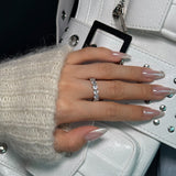Hand with lume jewellery's amore ring on a white bag