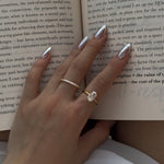 Hand with selene and ciel rings on an open book