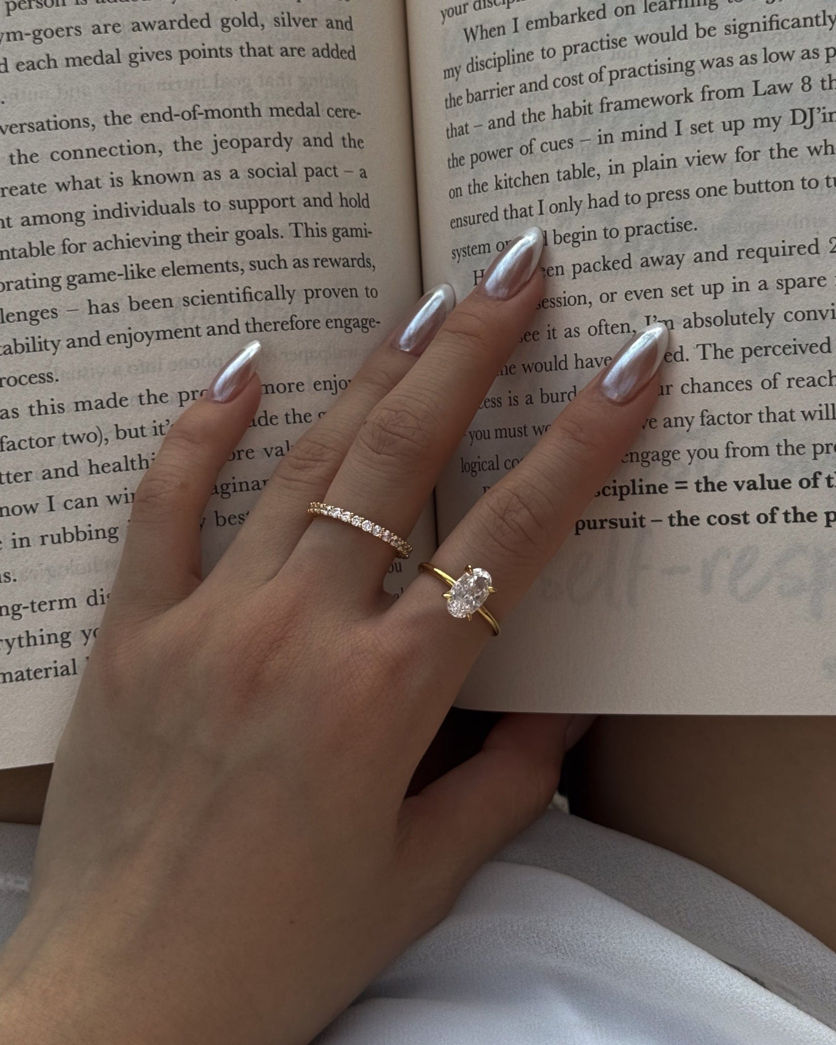 Hand with selene and ciel rings on an open book