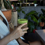 hand holding a drink with celeste ring and ciel ring on model in a cafe