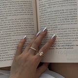 Hand with a selene ring and a ciel ring on an open book