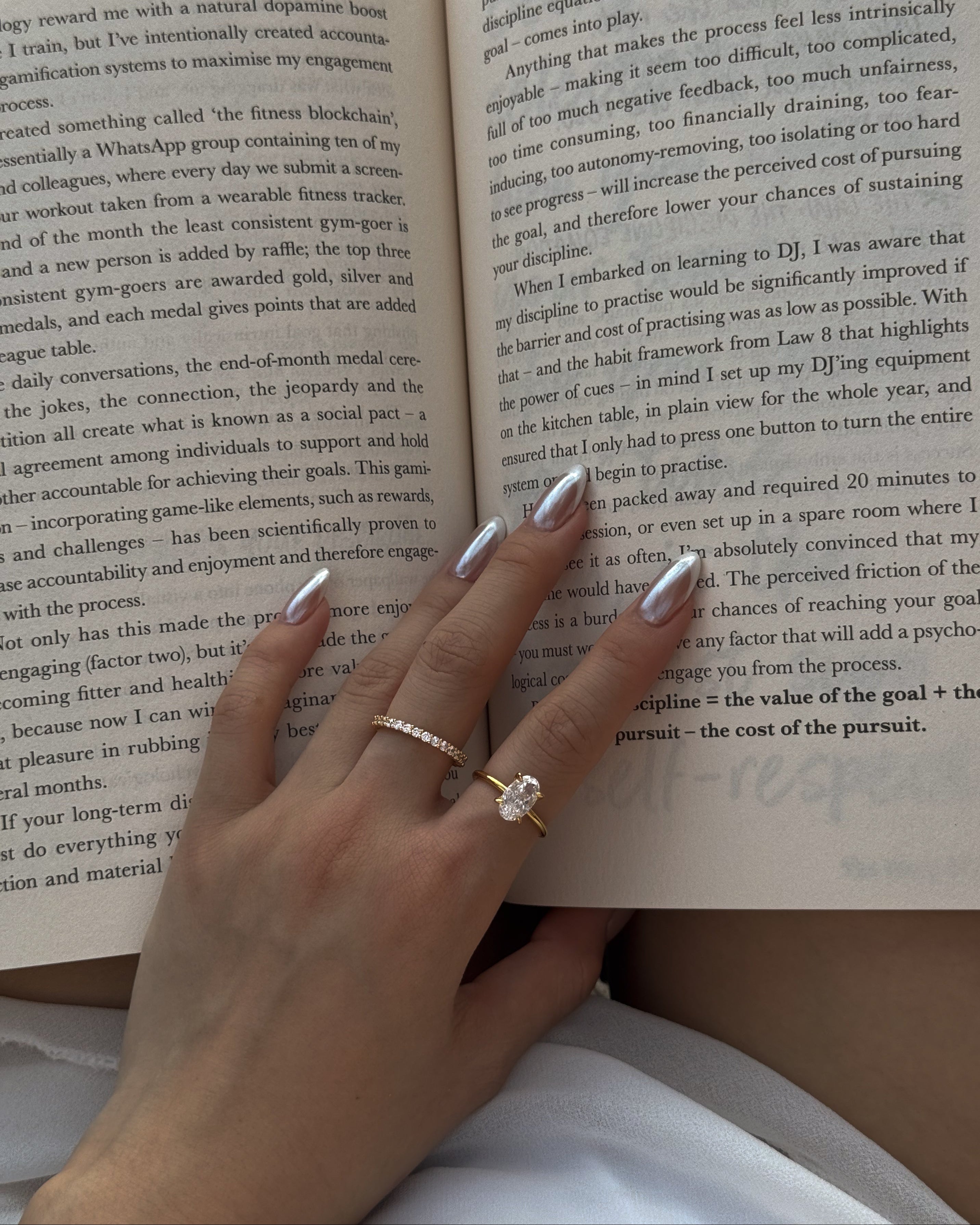 Hand with a selene ring and a ciel ring on an open book