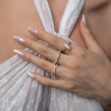 Close-up of a hand wearing ciel ring, celeste ring, vera ring with a blurred background