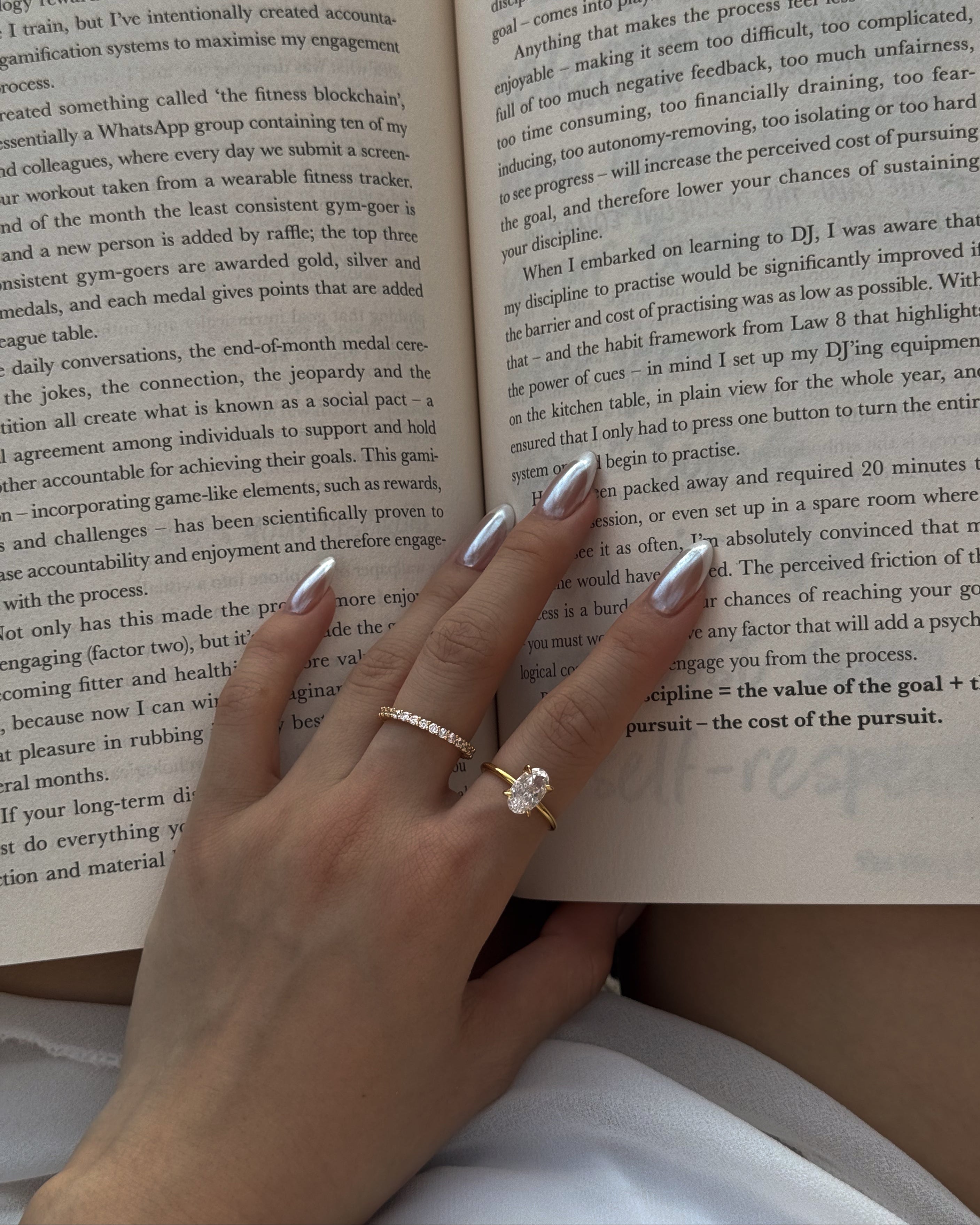 hand wearing a selene ring and a ciel ring with an open book
