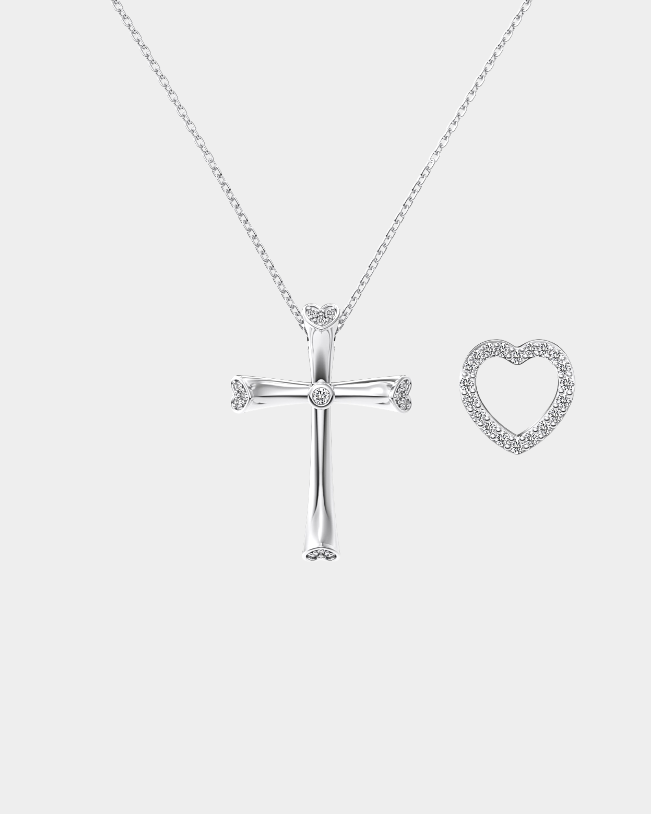Silver cross and heart-shaped pendant on a chain against a white background