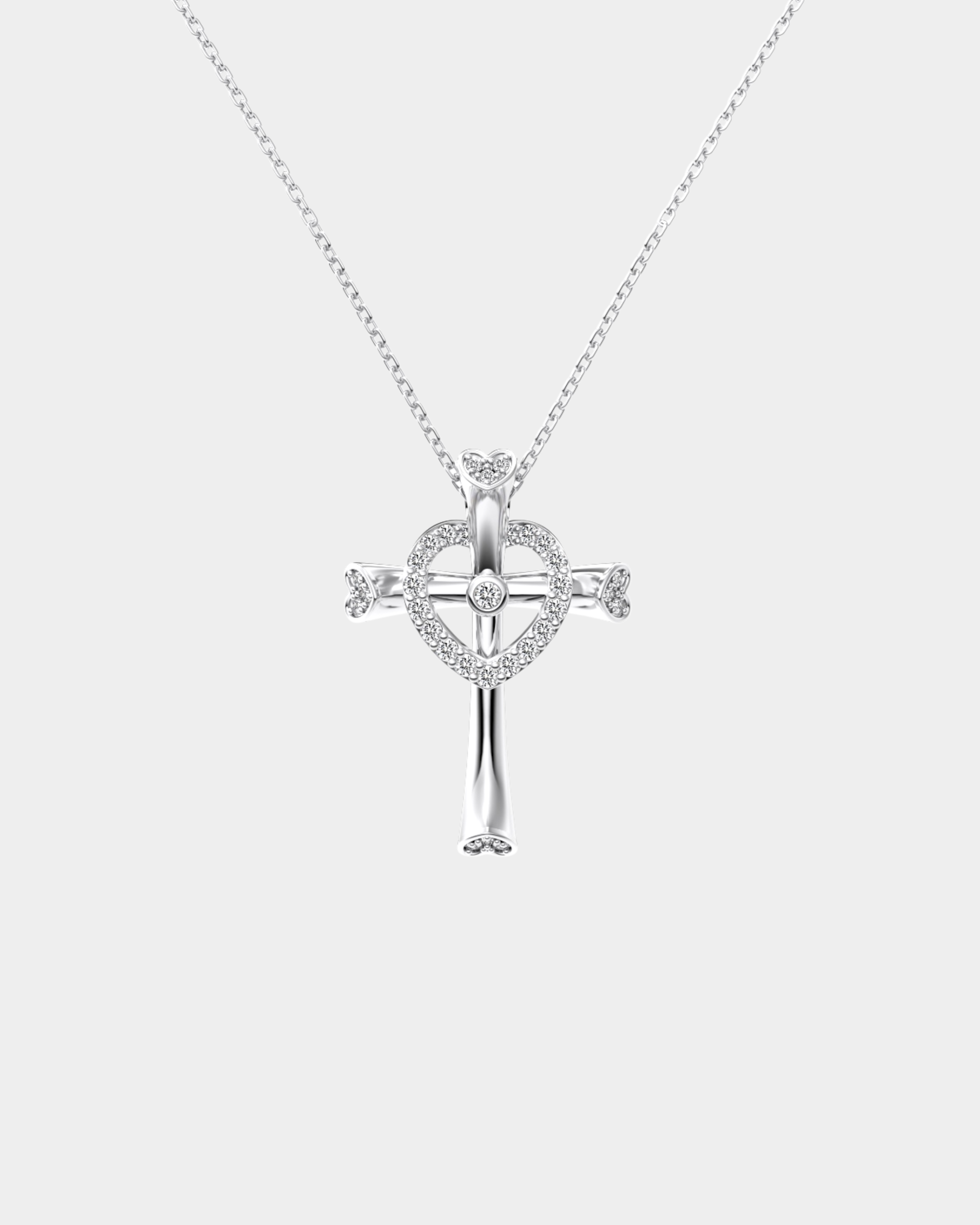 Silver cross necklace with heart design on a white background