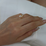 Hand wearing a ciel ring on a white dress