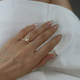 Hand wearing a ciel ring and a selene ring on a white dress